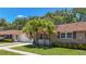 Charming home featuring a stone facade, well-maintained lawn, mature landscaping, and a lovely tile roof at 1102 Cara Dr, Largo, FL 33771