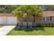 Charming home exterior with mature palm trees providing shade and a well-kept lawn at 1102 Cara Dr, Largo, FL 33771