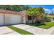 Lovely home featuring a two-car garage, stone accents, and verdant landscaping at 1102 Cara Dr, Largo, FL 33771