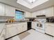 Bright kitchen features white cabinetry, tile backsplash and appliances at 1102 Cara Dr, Largo, FL 33771
