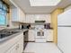 Bright kitchen features white appliances, tile floors and plenty of counterspace at 1102 Cara Dr, Largo, FL 33771
