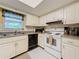 Bright kitchen features white appliances, tile floors and lots of natural light at 1102 Cara Dr, Largo, FL 33771
