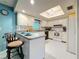 Bright kitchen features white cabinetry, breakfast bar, and appliances at 1102 Cara Dr, Largo, FL 33771