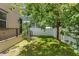 A tranquil backyard featuring lush green lawn, a privacy fence, and mature tree offers a serene outdoor space at 115 W Hiawatha St, Tampa, FL 33604