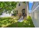 A well maintained backyard featuring a small porch and lawn, enclosed by a modern white fence, offers privacy and space at 115 W Hiawatha St, Tampa, FL 33604