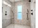 Luxury shower featuring double shower heads, mosaic tiles, and window at 115 W Hiawatha St, Tampa, FL 33604