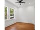 Bright bedroom featuring hardwood floors, a ceiling fan, and plenty of natural light from large windows at 115 W Hiawatha St, Tampa, FL 33604