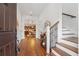 Bright foyer featuring hardwood floors, staircase with iron railing, and views into the kitchen and dining area at 115 W Hiawatha St, Tampa, FL 33604