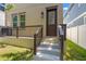 Front entry featuring a dark wood door and covered porch, offering curb appeal at 115 W Hiawatha St, Tampa, FL 33604