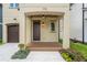 Charming front porch with detailed ceiling, ceiling fan, dark wood door, and elegant landscaping at 115 W Hiawatha St, Tampa, FL 33604