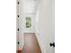 An inviting hallway with a hardwood floor, window, white trim, and natural light at 115 W Hiawatha St, Tampa, FL 33604