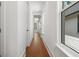 Hallway with hardwood floors, white walls, and natural light at 115 W Hiawatha St, Tampa, FL 33604