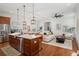 Open-concept living and kitchen space with hardwood floors, kitchen island and stainless appliances at 115 W Hiawatha St, Tampa, FL 33604