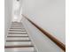 A staircase with white risers and a wooden handrail at 115 W Hiawatha St, Tampa, FL 33604