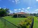 A spacious backyard with a well-maintained lawn and a partial view of the screen-enclosed patio at 1185 Rio De Janeiro Ave, Punta Gorda, FL 33983