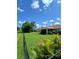 The home boasts a spacious backyard enclosed by a black chain-link fence with a lush green lawn at 1185 Rio De Janeiro Ave, Punta Gorda, FL 33983