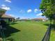 A large backyard features a well-maintained lawn with views of neighboring screen patios at 1185 Rio De Janeiro Ave, Punta Gorda, FL 33983