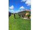 Spacious backyard with lush lawn, black chain link fence and a view of neighboring homes at 1185 Rio De Janeiro Ave, Punta Gorda, FL 33983