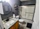 Modern bathroom featuring a stylish vanity, round mirror, and shower with sliding glass door at 1185 Rio De Janeiro Ave, Punta Gorda, FL 33983
