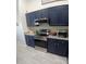 Contemporary kitchen features sleek stainless steel appliances, granite countertops, and stylish blue cabinetry at 1185 Rio De Janeiro Ave, Punta Gorda, FL 33983
