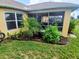 Inviting view of a screened-in patio from the backyard, enhanced by landscaping and a sun-drenched lawn at 1185 Rio De Janeiro Ave, Punta Gorda, FL 33983