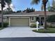 Inviting front exterior with a two-car garage and palm trees in the landscaped yard at 12749 Aston Creek Dr, Tampa, FL 33626