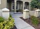 View of the front porch with decorative columns and landscaped walkway at 12749 Aston Creek Dr, Tampa, FL 33626