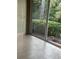 Enclosed patio with sliding glass doors showcasing verdant backyard landscaping at 12749 Aston Creek Dr, Tampa, FL 33626