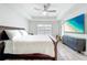 Tranquil bedroom with a ceiling fan, tray ceiling, large bed, and a mounted TV, designed for relaxation at 13045 Irwin Dr, Port Charlotte, FL 33953