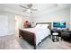 Relaxing bedroom with a ceiling fan, large bed, wooden furniture, and a sleek workspace with modern technology at 13045 Irwin Dr, Port Charlotte, FL 33953