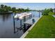 This dock features a pontoon boat, along with a chair for relaxing by the water at 13045 Irwin Dr, Port Charlotte, FL 33953