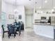 Open kitchen and dining space with white cabinets, granite counters, stainless appliances, and a glass dining table at 13045 Irwin Dr, Port Charlotte, FL 33953
