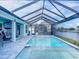 Sparkling screened pool with spa and covered patio offers a tranquil outdoor experience with waterfront views at 13045 Irwin Dr, Port Charlotte, FL 33953