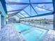 Screened-in pool and hot tub overlooking canal offer a private backyard oasis at 13045 Irwin Dr, Port Charlotte, FL 33953