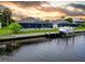 Beautiful waterfront property with boat dock, lush landscaping, and screened-in pool at 13045 Irwin Dr, Port Charlotte, FL 33953