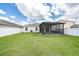 A spacious backyard featuring a well-maintained lawn, white fence, and a screened-in patio at 14524 Dunrobin Dr, Wimauma, FL 33598