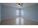Bright bedroom features tiled floors, a ceiling fan, and two windows with natural light at 14524 Dunrobin Dr, Wimauma, FL 33598