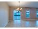 Open dining room with tiled floors, chandelier, and sliding glass doors leading to a screened lanai at 14524 Dunrobin Dr, Wimauma, FL 33598