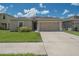Charming home featuring a well-maintained lawn, 2 car garage, and mature landscaping at 14524 Dunrobin Dr, Wimauma, FL 33598