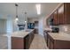 Modern kitchen featuring stainless steel appliances, granite countertops, tile backsplash, and an adjacent living area with fireplace at 14524 Dunrobin Dr, Wimauma, FL 33598