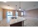 Open-concept kitchen with granite countertops, tile flooring, and an adjacent living area with ample natural light at 14524 Dunrobin Dr, Wimauma, FL 33598