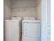 A compact laundry area equipped with a washer, dryer, and a shelf for storage at 14524 Dunrobin Dr, Wimauma, FL 33598