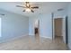 Spacious main bedroom with light-blue walls, tile flooring, ceiling fan, and access to en-suite bathroom at 14524 Dunrobin Dr, Wimauma, FL 33598