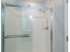 A glass shower with chrome hardware and white tiled surround, providing a clean and modern aesthetic at 14524 Dunrobin Dr, Wimauma, FL 33598