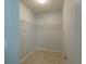 Spacious walk-in closet featuring ample shelving and tile flooring at 14524 Dunrobin Dr, Wimauma, FL 33598