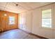 Bedroom with brown wood-paneled wall, white wall, damaged floors, and two windows at 1520 S Michigan Ave, Clearwater, FL 33756