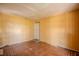 Bedroom with yellow walls, damaged floors, and a door leading to another room at 1520 S Michigan Ave, Clearwater, FL 33756