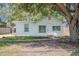 Charming single-story home featuring a quaint front yard shaded by a large tree at 1520 S Michigan Ave, Clearwater, FL 33756