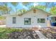 Charming single-story home with a stucco exterior, front yard, and shaded by mature trees at 1520 S Michigan Ave, Clearwater, FL 33756
