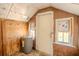 Laundry room featuring water heater, plywood walls, plywood trim and small windows at 1520 S Michigan Ave, Clearwater, FL 33756
